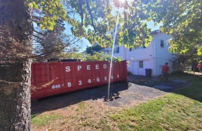 Dumpster being loaded with debris: Speedy Dumpsters